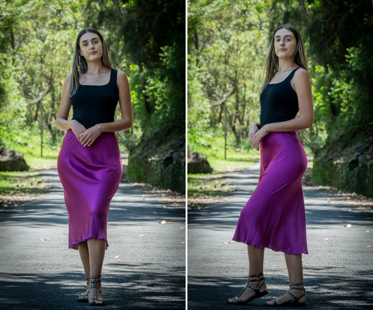 Femme qui porte jupe effet soie violette avec un top noir et des sandales