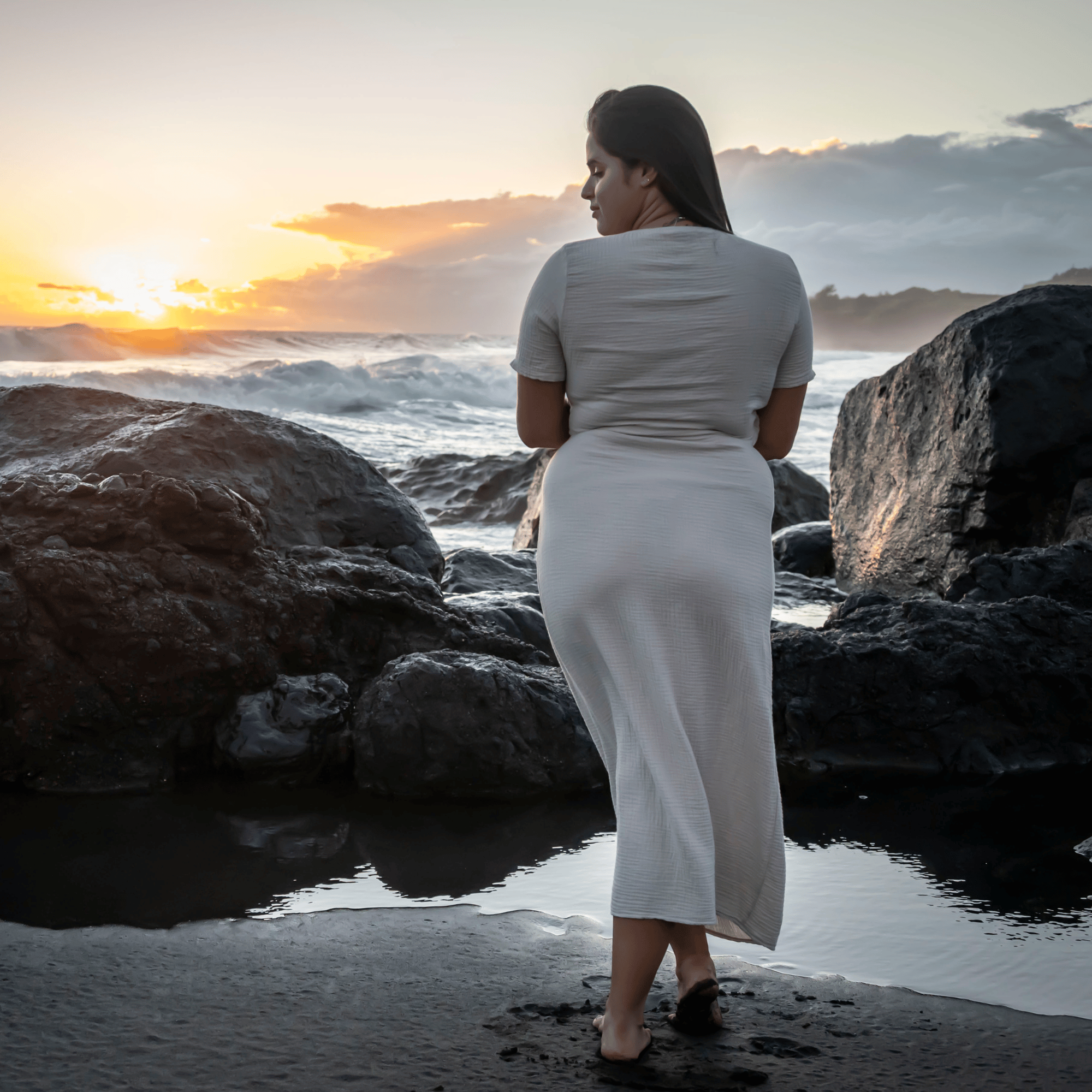 femme de dos portant une robe gaze de coton beige manches courtes en bord de mer à la Réunion