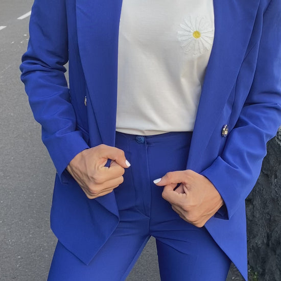 T shirt coton blanc avec marguerite sur la poitrine porté avec un ensemble tailleur pantalon bleu roi 